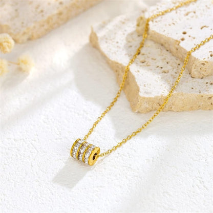 Gold necklace with a circular pendant on a light background