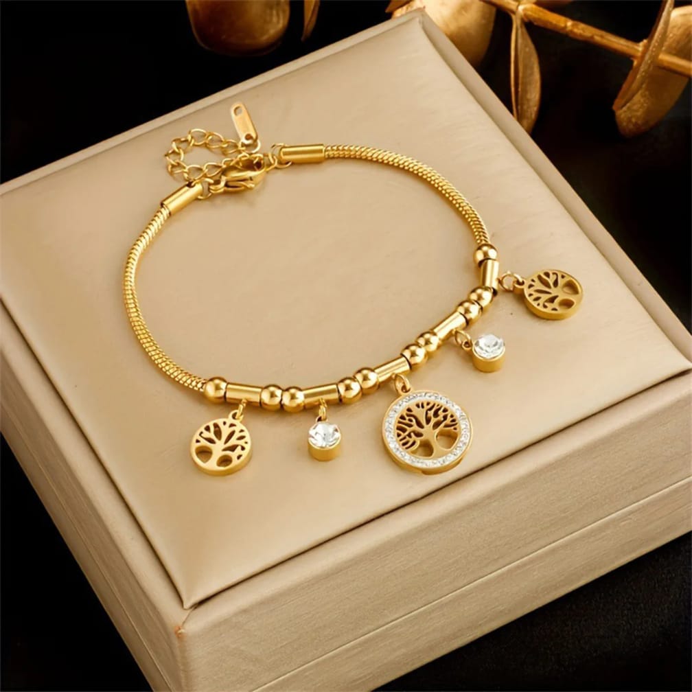Gold bracelet with charms on a beige jewelry box