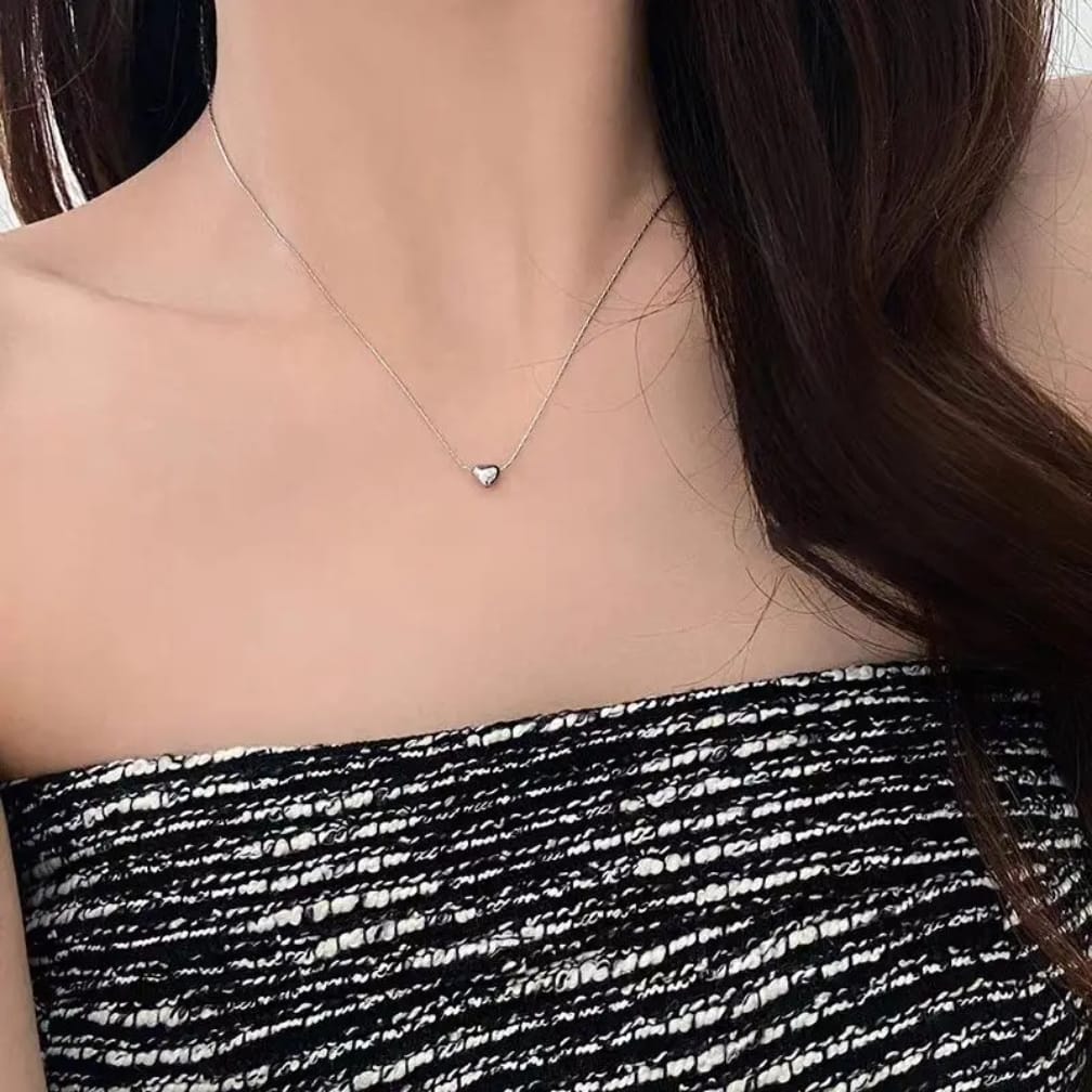 Necklace with a heart pendant worn by a person
