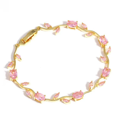 Gold bracelet with pink gemstones on a white background